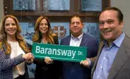 four trudell medical employees holding street sign for baransway drive