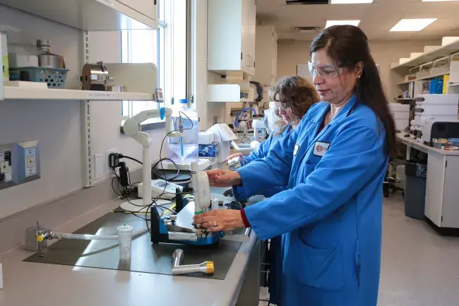 Two women work in a lab with aerosols.