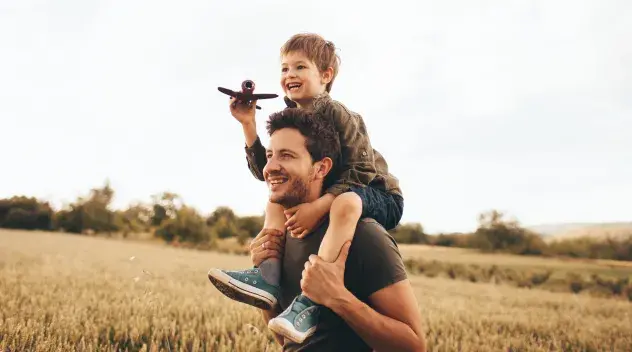 Child and parent playing in a field.