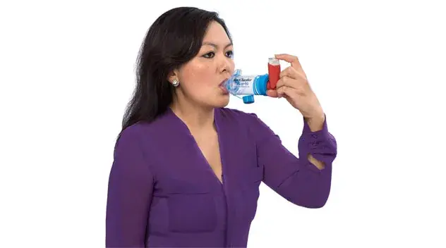 woman in purple shirt using aerochamber device